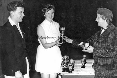 Badminton champions
Helensburgh and District Badminton Championships winners Frank Smith and Sheila Campbell receive their trophies from Mrs Rosina Williamson, wife of Provost J.McLeod Williamson, circa 1970.
