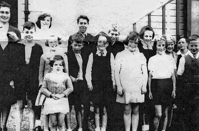 Glenmallon School
Pupils outside Glenmallon School on Loch Longside, circa 1940. Graham McGlone stands tall in the centre. Others are Herbert Gray, Alan Brough, Agnes Kirkwood, Norma Anton, Peter McKichan, Sheila Anton, Jessie Ronald, Joyce Russell, Maybeth Stevenson and Ernest ? One of the teachers is Miss Fergusson; the other possibly Miss Hattle. Image supplied by Stella Trainor, Ontario, Canada. 

