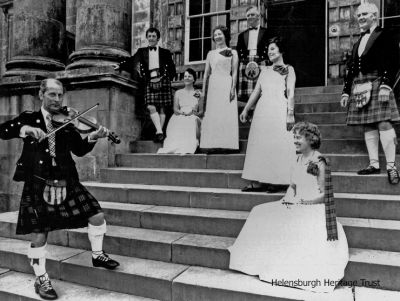 TV demonstration
Helensburgh and district members of the Royal Scottish Dance Society gave a demonstration at Rossdhu House, Luss, ancestral home of the Clan Colquhoun and now the Loch Lomond Golf Club clubhouse, for BBC programme "Great Britons â€” Robert Burns" in 1977. The violinist was Jimmy Yeaman, and the dancers from left were Bob Drummond, Etta Rennie, Mary McIntosh, George Rennie, Peggy Rose, Joyce Gregor and Ken Sharp. Image supplied by Anne Thorn.

