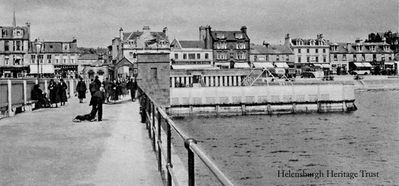 Helensburgh Pier
Walkers are out in force in this old image of Helensburgh Pier and the outdoor swimming pool. It also clearly shows the archway which used to stand at the entrance to the pier. Image date unknown.
