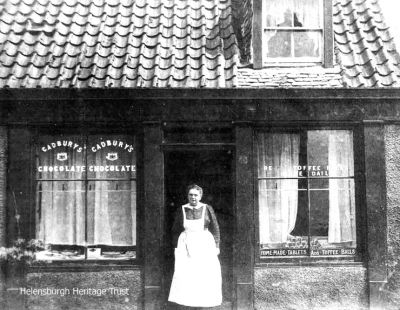 Reece's Sweet Shop
Margaret Reece outside her sweet shop at the corner of Maitland Street and East Clyde Street, Helensburgh. Image, date unknown, supplied by Sue Taylor.
