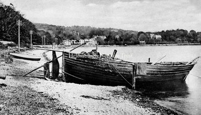 Old boat at Rhu Point
The fishing vessel Effie is beached on Rhu Point, with the village in the distance. The big house on the right is Rowmore. Image circa 1906.
