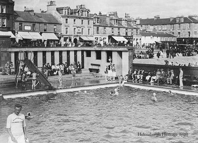 Outdoor pool
A busy day at Helensburgh's outdoor swimming pool beside the pier. This photo, from a family album, was supplied by Donald Watson. Image date unknown.
