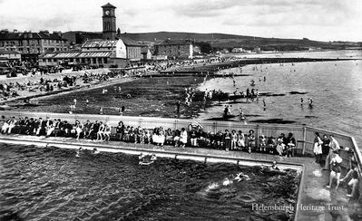 Outdoor pool
Helensburgh's outdoor pool on a sunny summer day, with townsfolk and trippers on the beach beyond. The Granary Restaurant and the Old Parish Church are prominent. Image date unknown.
