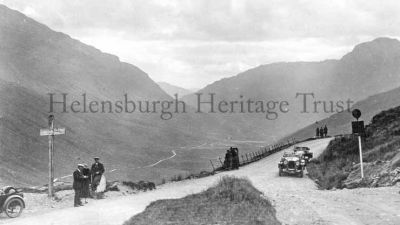 Rest And Be Thankful
Cars parked at the top of the Rest and Be Thankful as passengers look down Glen Croe, circa 1927.
