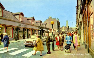 Macvicars
Pedestrians use the crossing at the foot of Sinclair Street, Helensburgh, in front of Macvicars clothing store in the 1960s.
