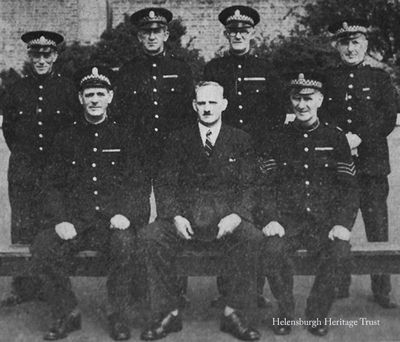 World War Two Specials
The town's Special Constabulary during the Second World War. Standing from left: George Loban, Hermitage janitor Tom Dunlop, railway official George Hastings and Henry Taylor, the West Clyde Street chemist; seated: school attendance officer Hugh Clark, Sergeant William McGillivray and coal merchant Robin Spy. The Sergeant came to Helensburgh in 1938 and served in the town until 1945. He later lived in Motherwell and Stirling, then Dunblane where he became deputy custodian of Dunblane Cathedral.
