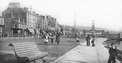 West Bay
Looking east along West Clyde Street towards the Henry Bell monument and the Old Parish Church, in the days when there were railings between the pavement and the grass. Image date unknown.
