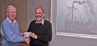 Sponsorship
John Urquhart (right) of LoveLochLomond presents a sponsorship cheque for Â£300 to bicentenary celebrations committee chairman Stewart Noble at a meeting of Helensburgh Heritage Trust on March 28 2012. Beside them is an image of the Comet replica sailing across the Clyde in 1962 to mark the 150th anniversary.

