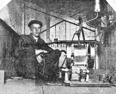Baird's electric light plant
As a schoolboy John Logie Baird installed an electric light plant in the family home, the Manse, in West Argyle Street, Helensburgh. He is seen here with part of the plant. A home-made dynamo was driven by a water-wheel connected to the water main, and with a collection of jam jars and sheet lead successfully generated current.
