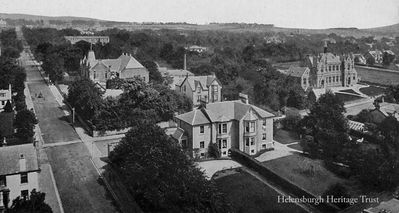 1903 Sinclair Street
Helensburgh's Public Hall, the Victoria Hall, and Hermitage School are seen in this 1903 photograph from the top of the St Columba Church tower, looking up Sinclair Street, which was published as a postcard by J.Valentine & Co. of Dundee. It shows the chimney of the Malig (or Millig) Mill to the rear of the Victoria Hall.
