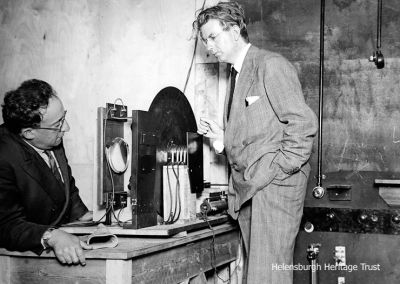 Daylight TV
An October 3 1929 photo of John Logie Baird explaining the mechanism of the television receiver while testing daylight transmission. His latest experiments in daylight transmission featured  Swedish exercises performed by an instructor transmitted to the receiver in movie form. On the left is his technical assistant, Ben Clapp.
