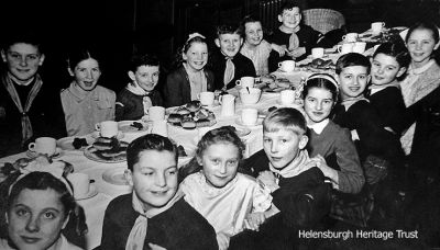 Cub Party
One of several tables at a Helensburgh Cub Party. Back row (from left): Neil Burgess, Margaret Lyon, Billy Campbell, ?, Teddy Boyle, ?, ?; front: Doreen Hunter, Bertie Donaldson, Helen Orr, Angus Tran, sister and brother Campbell, Gordon Fraser, Maggie Rice. Image, circa 1948, supplied by Gordon Fraser.
