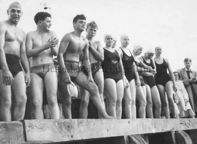 1960 Craigendoran Swim
Helensburgh Swimming Club prepare to dive from Craigendoran pier to swim to Helensburgh pier in the annual event in August 1960. The first girl is club champion for many years Sheila Bell, next to her is Elspeth McLean, and fifth girl along is Sandy MacRitchie. The boy second from right rubbing his hands is Colin McCallum. Further details would be welcomed by the editor.
