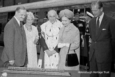 1965 Royal Visit
The Queen and the Duke of Edinburgh are pictured in Helensburgh Central Station admiring a model of the first 'Blue Train' which were introduced into service on the Helensburgh-Glasgow line in 1960. The 15 minute visit was on Monday June 28 1965 to open new Dunbartonshire County Counci officesl in Garshake Road in Dumbarton and the royal couple arrived at and left Clydebank on the Royal Yacht Britannia. With them are Provost J.McLeod Williamson and his wife Rosina. Photo by courtesy of Helensburgh Memories on Facebook.

