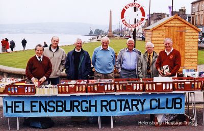 Rotary bookstall
Members of Helensburgh Rotary Club pictured running a bookstall beside the esplanade putting green in 2002. From left: Denis Taylor, Dilwyn Jones, Jim McBlane, Gordon Hattle, George Boyd, ?, and Graham Smith.
