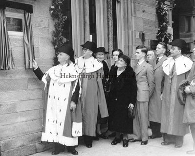 Burgh plaque unveiled
On May 1 1952 a commemorative plaque for John Logie Baird was unveiled at Helensburgh's Municipal Buildings. On the left is Provost William Lever performing the unveiling. On his left are one of the Bailies, then Annie Baird, Diana Baird, Jean Conley (nee Baird), Malcolm Baird, two councillors or officials, and the second Bailie.   
