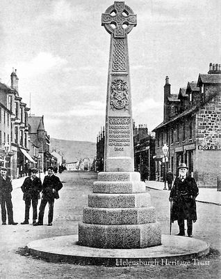 Centenary Cross
The pink granite Centenary Cross, donated in 1902 by Sir James Colquhoun of Luss to mark the centenary of the granting of the Burgh Charter, in its original position in the centre of Colquhoun Square. It was moved to the north west quadrant as it had become a traffic hazard. Image date unknown.
