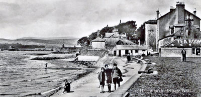 East Bay
Three children pose for a picture on Helensburgh's East Bay, with the pier in the distance and a tea room â€” now a motor spares shop â€” on the right. Image date unknown.
