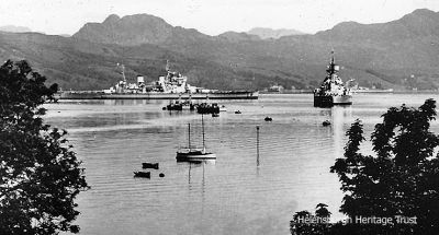 Gareloch battleships
Two battleships are seen laid up in the Gareloch. Three King George battleships were laid up in the loch, and the vessel broadside in the image is one of them and the one bow facing could be another. The three were King George V, Anson and the John Brown's-built Duke of York. Anson was towed to the Gareloch in 1951, purchased by Shipbreaking Industries at Faslane on December 17 1957 and subsequently scrapped. Duke of York was moved to the Gareloch in November 1951 and scrapped at Faslane from May 1957. King George V also came to the Gareloch and in 1958 was moved to the ship breaking firm of Arnott Young and Co. in Dalmuir. These facts date the image, supplied by Brian Cook, to between 1951 and 1957.
