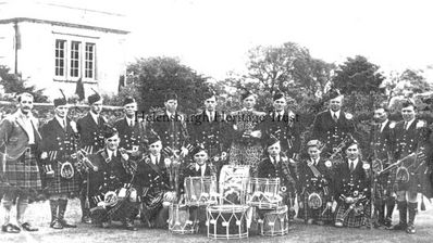 Helensburgh Pipe Band 1938
Members of Helensburgh Pipe Band at Rossdhu House, Luss, with Sir Ian Colquhoun (left) after receiving new uniforms to play at the Empire Exhibition. Standing: Pipe Major Thomas Neil, J.Strang, Watson, W.Camlin, A.MacKillop, J.Copeland, A.Hamilton, A.MacKean, T.McGregor, Pipe Sergeant T.Campbell, band secretary B.Watson; front: Stewart, Garrity, T.Fagan, Robinson, J.Cameron, J.Martin.

