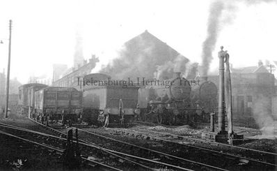 The Helensburgh Shed
Steam locomotives at the Helensburgh shed beside the Central Station, with the St Columba Church tower barely visible through the haze. Image date unknown.
