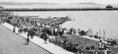 Seafront and pier
Summer crowds pack Helensburgh's west esplanade, with the pier beyond, and some youngsters are paddling. Image circa 1912.
