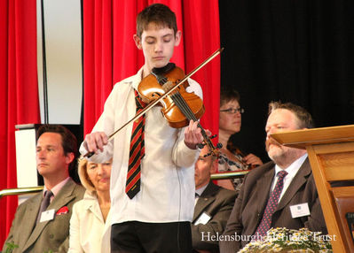 Academy opening
Talented young violinist Ryan Young plays a set of reels during the official opening of the second Hermitage Academy at Colgrain on June 4 2008. On the left of the picture is the Duke of Argyll. Photo by Donald Fullarton.
