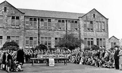 Gift of fruit
Pupils and teachers at Hermitage Park gather to receive a gift of apples from the British Columbia Fruit Growers in Canada in 1951. Miss Lennie presided over the distribution to the children. Image supplied by Cecilia Dunlop.
