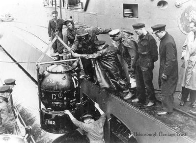 Loading mines
A Vickers T Mk3 exercise mine is loaded aboard the Dutch submarine O19 in Loch Long off Arrochar during World War Two. Picture courtesy of www.dutchsubmarines.com
