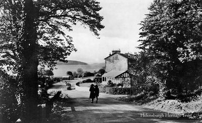Mill Brae, Kilcreggan
A view of the lower part of the Mill Brae, the steep hill down into Kilcreggan. The low wooden house was for many years the home of Mrs Lucy Rickerman, who lived to the age of 105 before her death in 1980 and was the only person to be awarded the title of Burgess of the Burgh of Cove and Kilcreggan. She was also the oldest person ever to live in Helensburgh and district. Image circa 1962.
