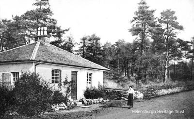 Old Toll House
A lady, possibly the then owner, stands outside the Old Toll House at the top of Sinclair Street. In 2018-19 the little building was substantially expanded and modernised, and is a private dwelling. Image date unknown.
