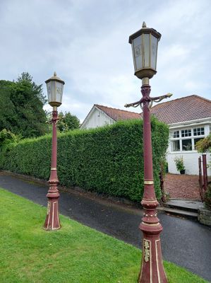 Provost's Lamps
 It was a tradition that provosts of Helensburgh had a special lamp post erected outside their house during their term of office. This photograph shows the two lamp posts which stood outside Billy Petrie's house at Segton, John Street at the time of his death in 2022. The coats of arms on the glass are for Dunbartonshire County Council, Dumbarton District Council, Argyll and Bute Council, and Strathclyde Regional Council. He had been provost of the first three of these councils, but not of the last - quite probably a unique state of affairs. 
Keywords: Provosts Lamps