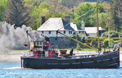 Puffer VIC 32
The puffer VIC 32 passes Rosneath's historic Ferry Inn while steaming through Rhu Narrows on May 3 2017. VIC 32 was built by Dunstonâ€™s of Thorne, Yorkshire, at Rowhedge in November 1943. This was a busy time for the Clyde shipbuilding yards and the Admiralty needed 50 â€” later 100 â€” victualling boats in a hurry. So they were built in groups of three by various different yards in England. In 1989 the â€œFriends of VIC 32â€ group was started, a money raising venture in case of an engineering or other crisis, and there are now hundreds of Friends. The vessel is operated by Puffer Steamboat Holidays Ltd. and offers five day cruises in the West Highlands each summer. Photo by Stewart Noble.
